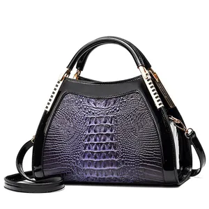 Detailed side view of purple crocodile texture handbag with black patent leather accents