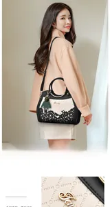 Detail of hollow floral patterns and hardware on black and white PU leather tote bag