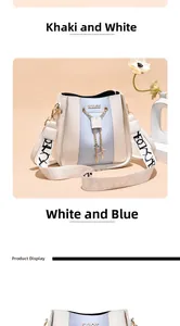 Close-up of stylish cream bucket bag with blue panel, gold chain, and patterned strap