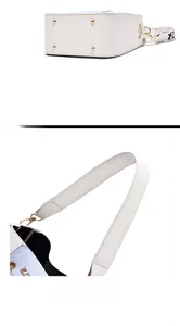 Detail view of white bucket bag bottom studs and wide comfortable handle strap
