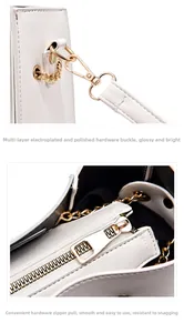 Macro shot of gold-tone metal hardware and smooth zipper on a white bucket bag.