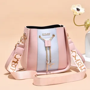 Fresh pink and light blue panel bucket bag with gold chain charm and wide shoulder strap