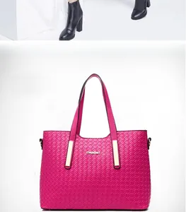 Dettaglio della borsa tote fucsia con trama intrecciata, logo metallico e cuciture