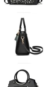 Detail of black PU tote bag with white floral laser cutouts and pearl accents