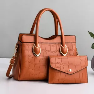 Detail of brown crocodile pattern handbag set with golden hardware and matching pouch