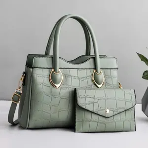 Detail of light green crocodile embossed PU leather handbag set with gold hardware