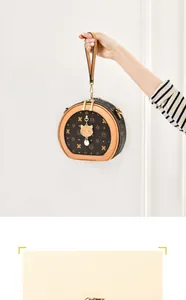 Détail du sac rond à monogramme avec pendentif chat doré et double fermeture éclair