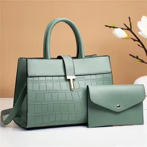 Detail of mint green tote with crocodile pattern and matching envelope coin purse