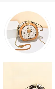 Détail du sac bandoulière rond avec pendentif chat doré et bordure en cuir orange