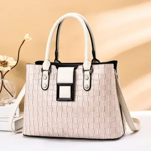 Detail der beigen geflochtenen Handtasche mit schwarzer Schnalle und feinem Schultergurt