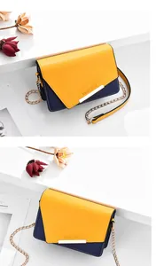 Detalle de bolso bandolera bicolor con herrajes dorados y texto de Romantic Paris