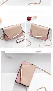 Detalle del mini bolso bandolera bicolor con barra metálica dorada y correa de cadena