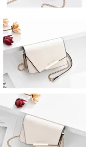 Detalle de bolso bandolera crema con texto Romantic Paris y herrajes dorados