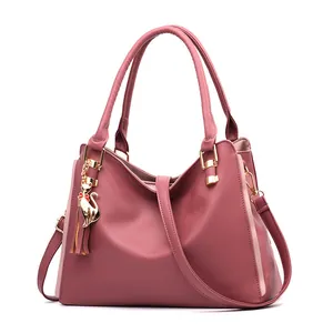 Pink faux leather tote bag for women with cat tassel charm and crossbody strap