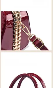 Detail der dunkelroten Lackledertasche mit goldenen Beschlägen und genähtem Griff