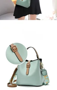 Detailed view of mint green bucket bag featuring brown strap accent and jacquard shoulder strap