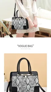 Close-up of snakeskin pattern tote with golden lock detail and stylish leather handles