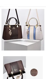 Detail of elegant monogram tote bags featuring golden hardware and decorative leaf pendants