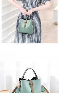 Detail view of a light green bucket bag with brown trim and adjustable wide shoulder strap