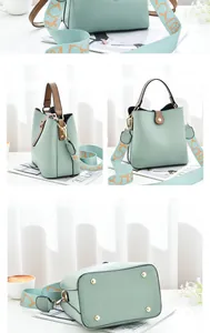 Detail view of mint green bucket bag featuring brown leather handle and wide strap
