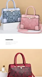 Detail of snake skin pattern handbags in light blue, pink and dark red with metal charms