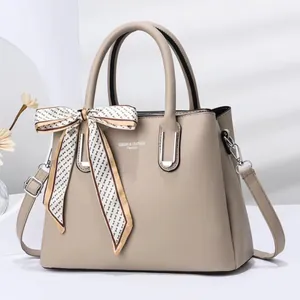 Detail of stone pattern texture handbag with elegant silk scarf and shoulder strap