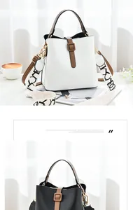 Detail of minimalist bucket bag showing smooth PU leather texture and lettered canvas strap
