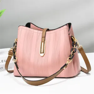 Pink wave textured bucket bag with brown leather strap and gold chain link details