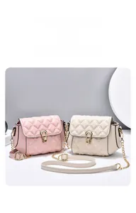 Close-up of pink and beige quilted chain crossbody bags with metal horseshoe clasps