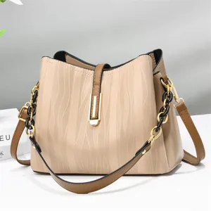 Elegant beige bucket bag with vertical wave texture and brown leather shoulder strap