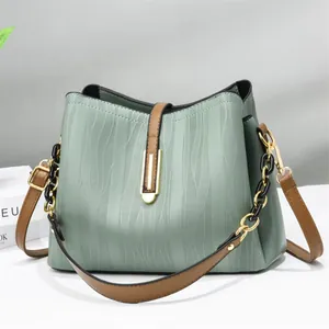 Elegant mint green water-ripple textured bucket bag with brown trim and gold chain strap