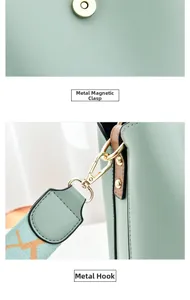 Detail of light green bucket bag showing gold magnetic clasp and metal hanging buckle