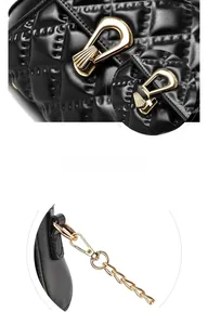 Close-up of black quilted leather bag with golden hardware and fashion chain strap