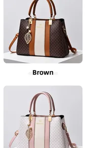 Detail view of stylish leather tote bags with leaf pendant and luxury monogram pattern