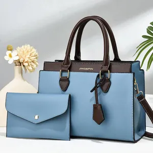 Light blue two-piece tote bag set with brown handles and a matching envelope clutch bag