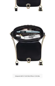 Detail view of black quilted crossbody bag showing organized interior and horseshoe buckle