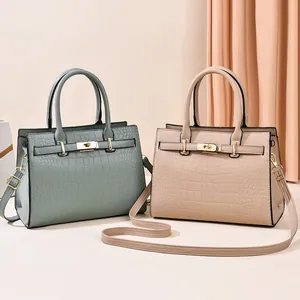 Elegante borsa a mano in coccodrillo con chiusura girevole dorata in verde e beige