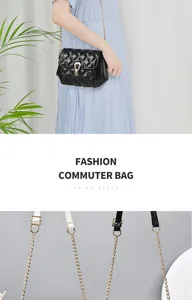 Detail of golden metal chain strap and horseshoe clasp on black quilted crossbody bag