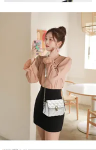 White quilted small crossbody bag with gold hardware and chain strap on a female model