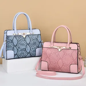 Women's faux snake skin tote bags in light blue and pink with elegant gold hardware