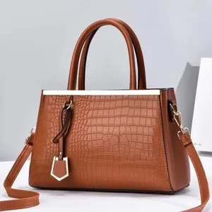 Brown crocodile embossed faux leather handbag with gold hardware and top handles