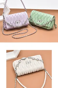 Detailed view of matelassé quilted bag texture with rhinestone lock and chain strap