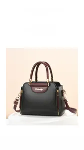 Close-up of contrast color tote bag with burgundy flap and golden metal hardware