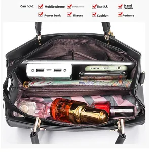 Interior view of black leather handbag showing large capacity for phone and cosmetics