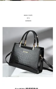 Detailed view of black crocodile pattern cowhide handbag with elegant gold hardware