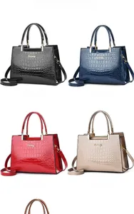 Detail view of glossy crocodile embossed handbags in black, blue, burgundy, and khaki colors