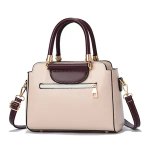 Contrast color handbag in beige and burgundy PU leather with gold hardware and shoulder strap