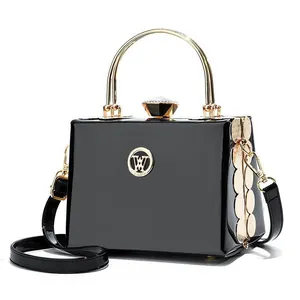 Luxurious black patent leather evening handbag with gold ring handles and crystal buckle
