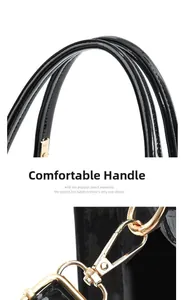 Detail of glossy black patent leather handbag with gold hardware and comfortable handles