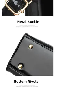 Detail of gold metal buckle and protective studs on black faux crocodile leather bag